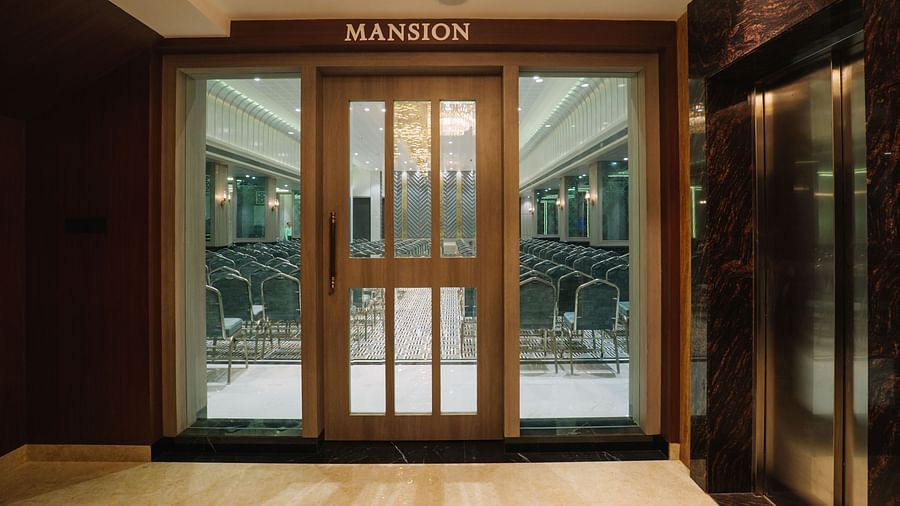 An entrance to a room featuring ornate glass doors and a patterned carpet in a well-lit area - Melior Inn