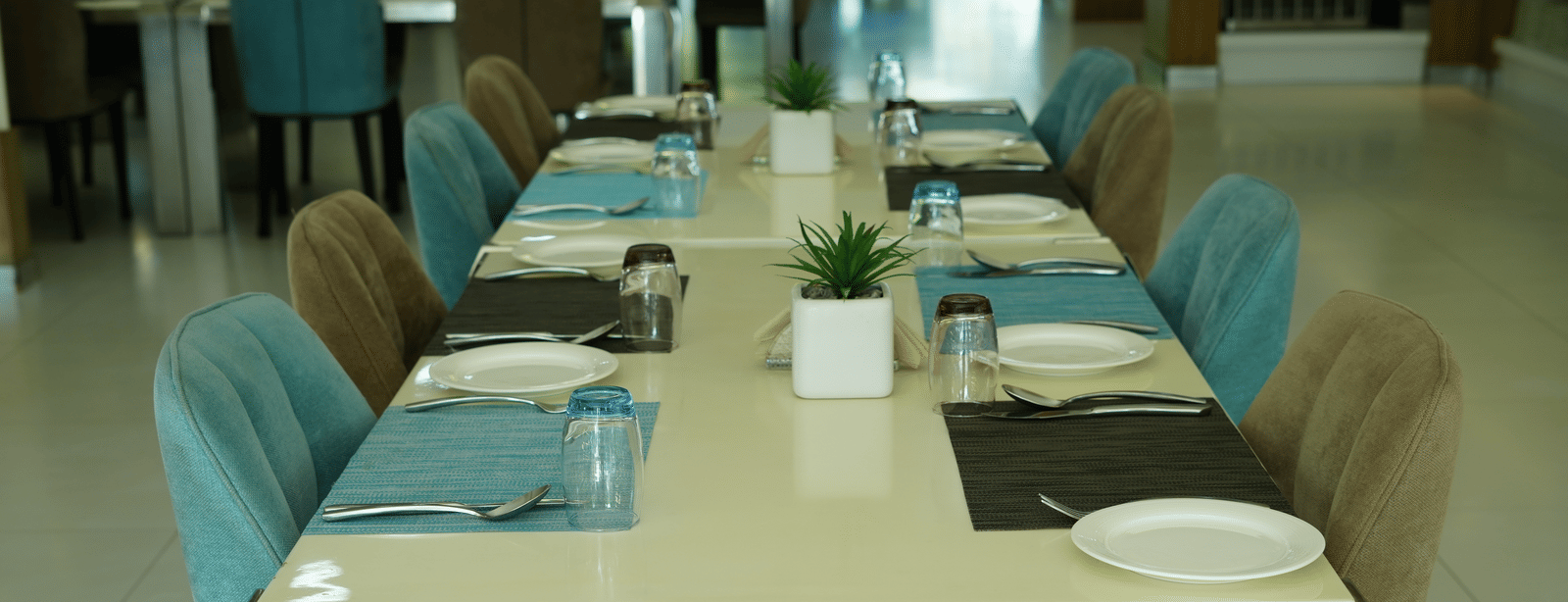 Dining table set with plates and glasses in a restaurant at Grande Bay Resort & Spa.