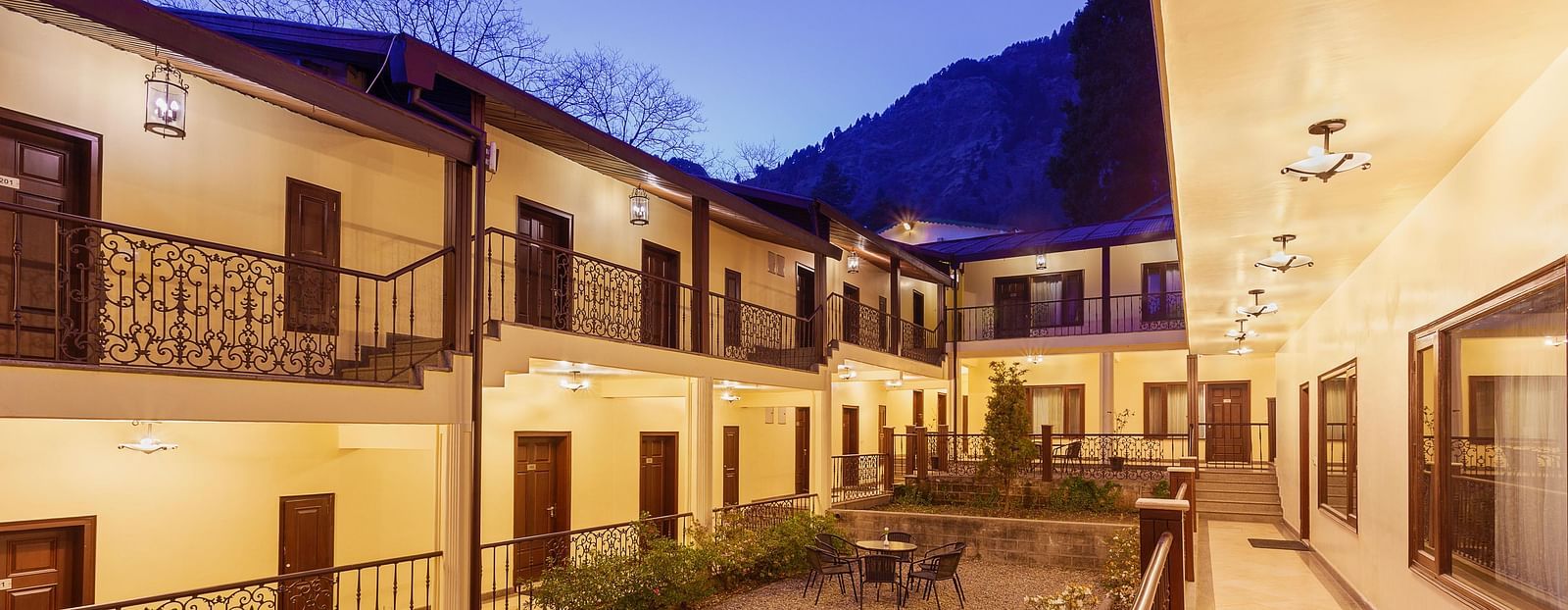 a well lit seating area in the hotel interior with tables with chairs in clusters - The Earl's Court, Nainital