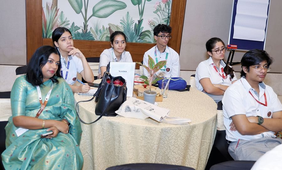 Group of participants seated at a table during a discussion - Karma Lakelands.