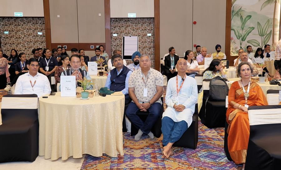 Audience seated at round tables during a presentation - Karma Lakelands.