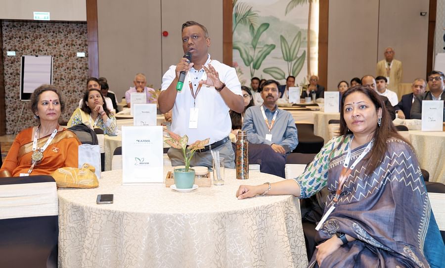 Attendees at a table interacting during a formal gathering - Karma Lakelands.