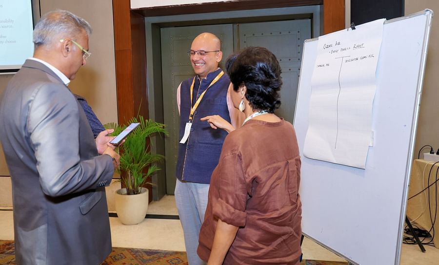 Group of people engaged in a discussion near a presentation board - Karma Lakelands.