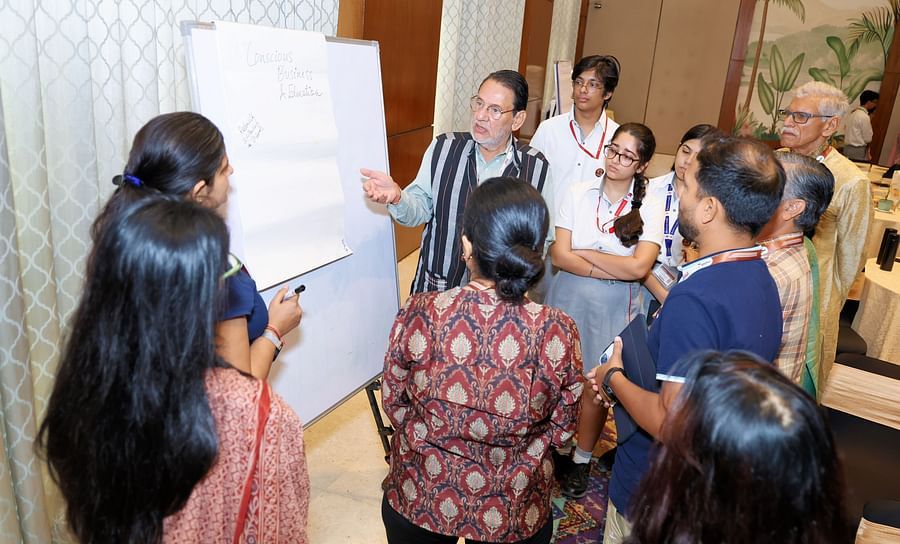 Group of people engaged in a discussion near a presentation board - Karma Lakelands.