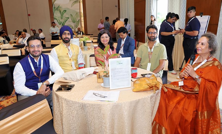 Group of participants seated at a table during a discussion - Karma Lakelands.