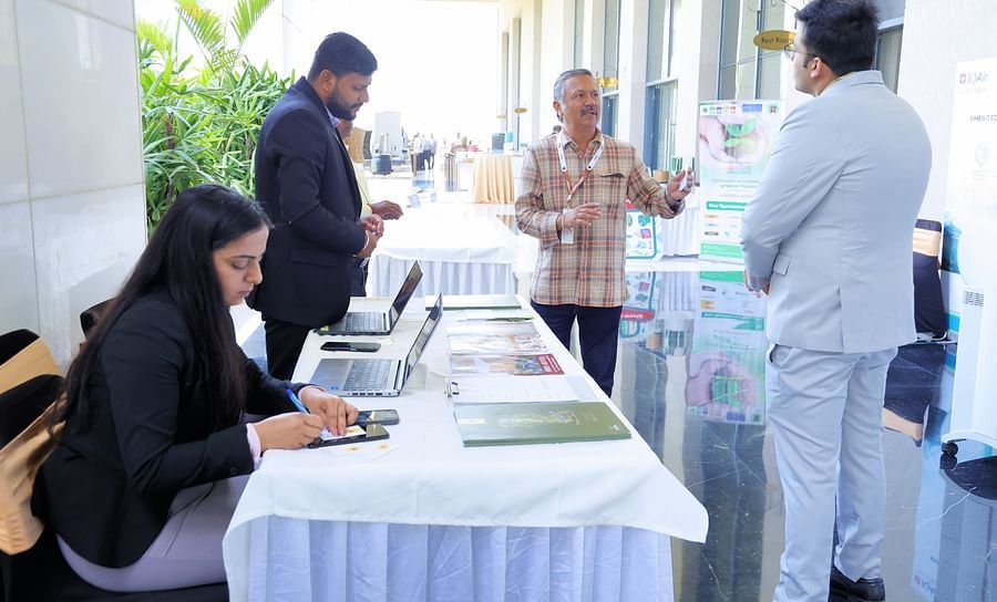Group of people engaged in a discussion near the registration table - Karma Lakelands.