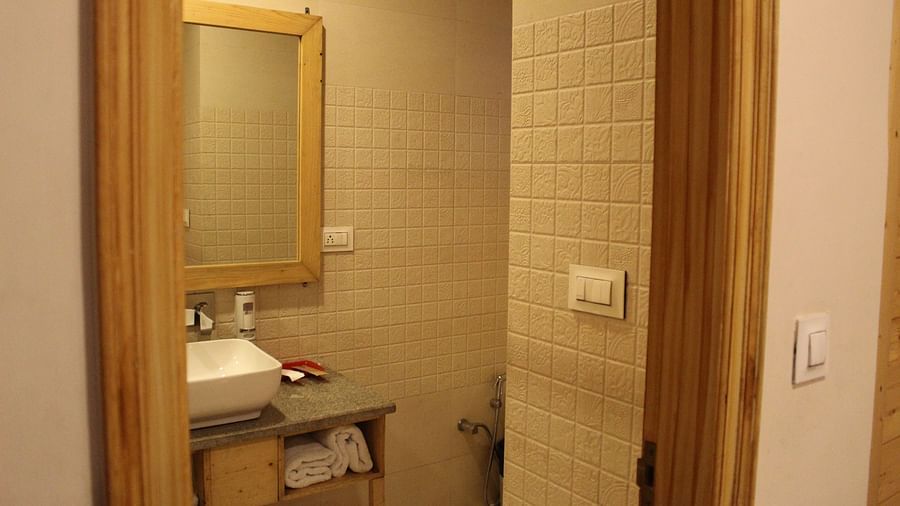 Compact bathroom with a mirror, sink, and towel rack at Dagshai Manor Kasauli - Inde Hotels.