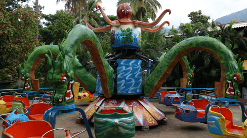 A lively amusement ride shaped like an octopus, with rotating arms and seats, entertaining families - The Black Thunder