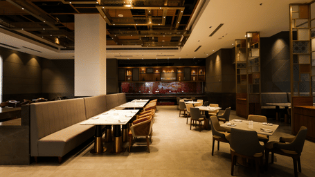 Spacious restaurant with wooden interiors and multiple dining tables at Ramada by Wyndham Sonipat Murthal