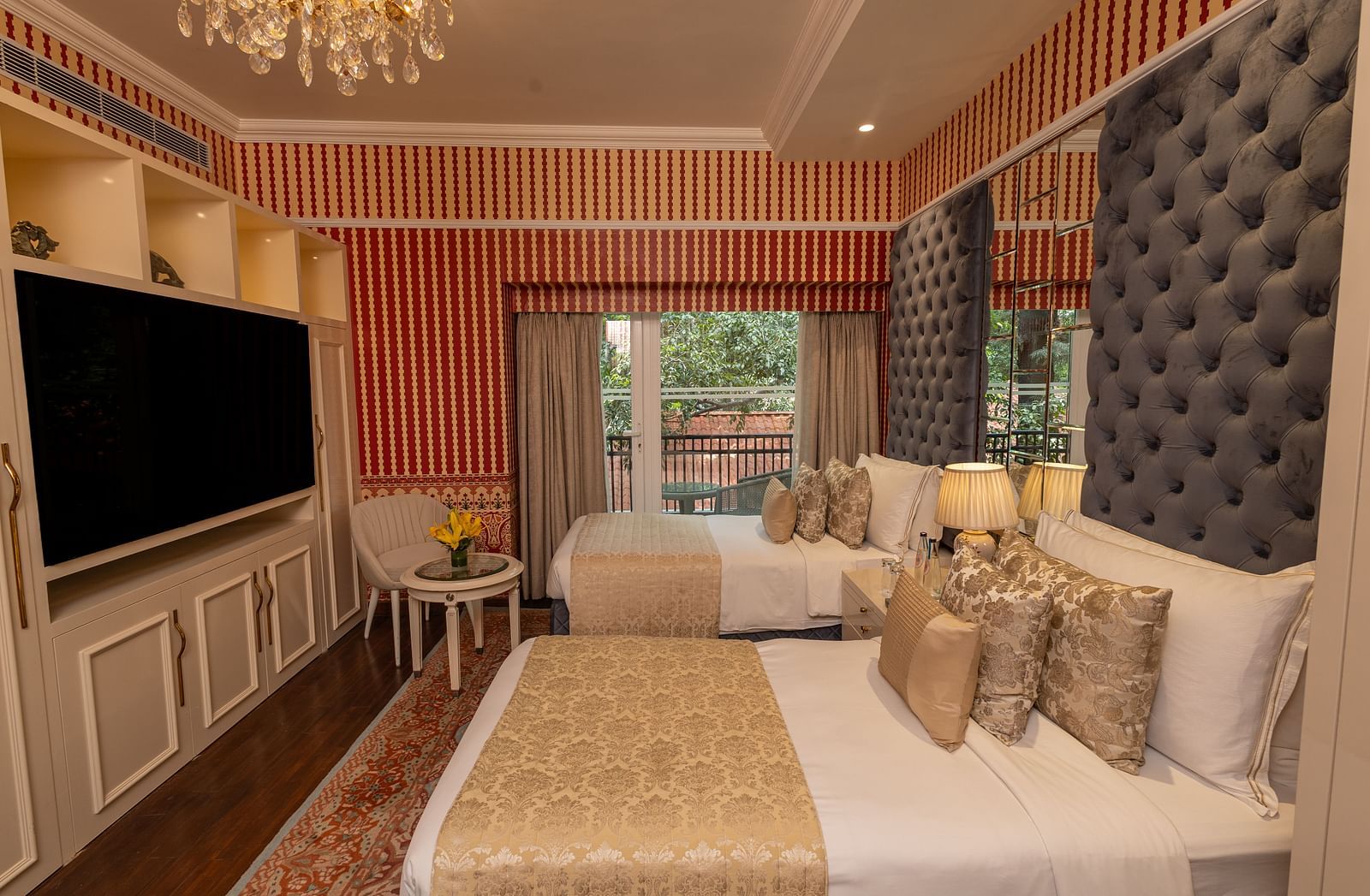 Luxury Twin Bed Room with Balcony at The Claridges New Delhi, featuring twin beds with pillows and a wall-mounted TV
