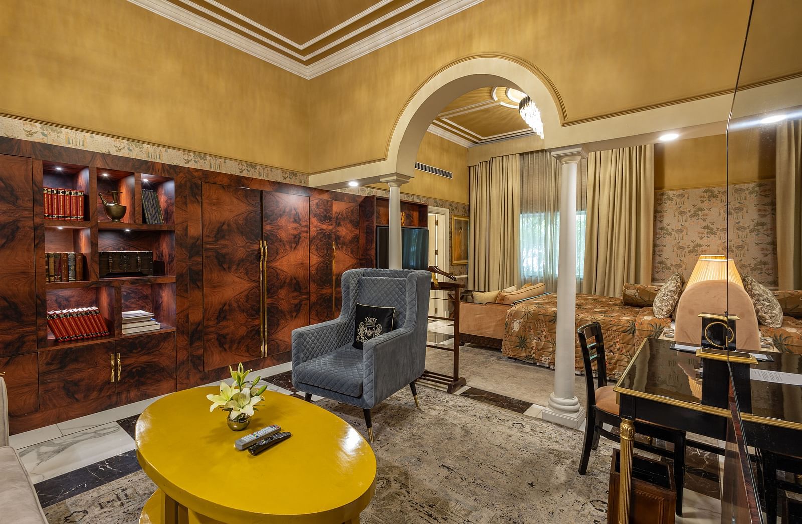Executive Suite at The Claridges New Delhi, featuring a corner view of the room with a wall-mounted TV, cosy sofa, and a round table in front