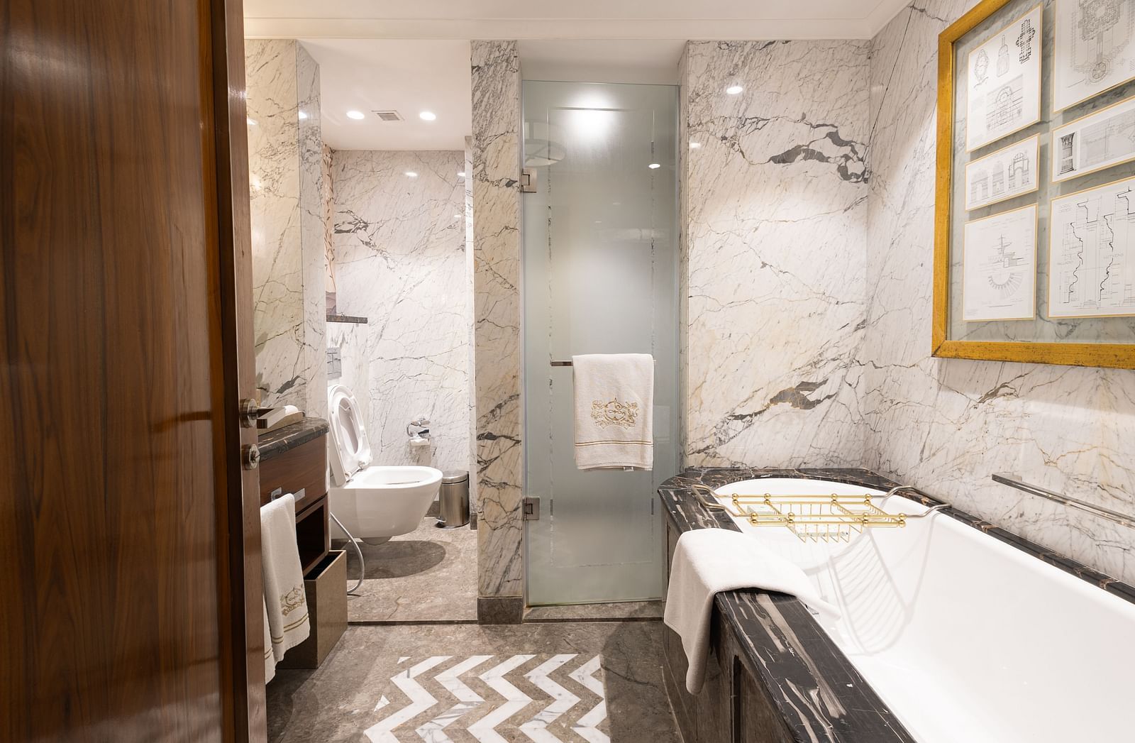 Luxury King Bed Room washroom at The Claridges New Delhi, featuring a bathtub and a glass-enclosed bath area
