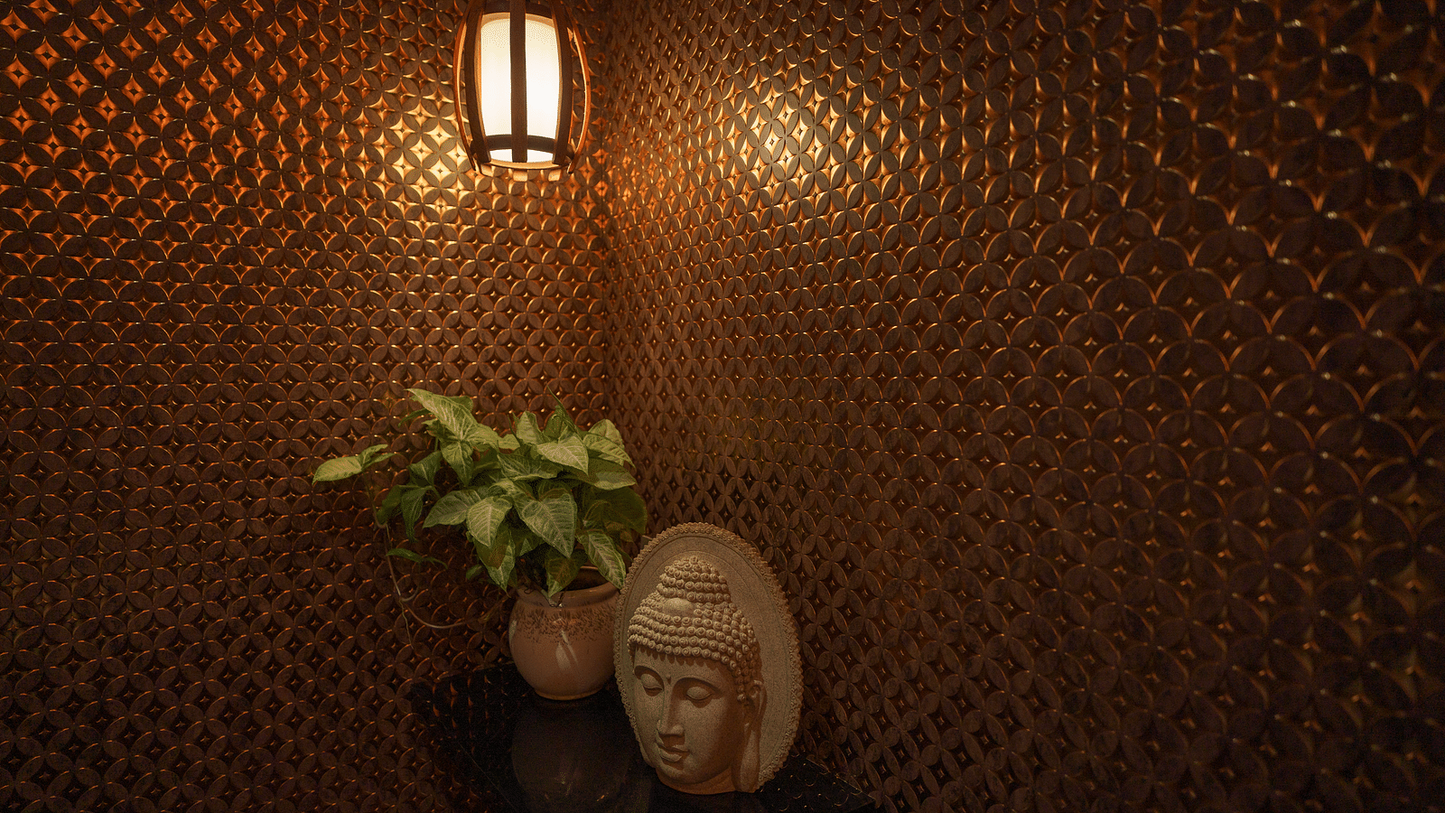 Image of an aesthetic corner of the spa at Coral Reef Hotel & Spa in Port Blair featuring a warm lit lamp below which a plant and a showpiece of Buddha is placed