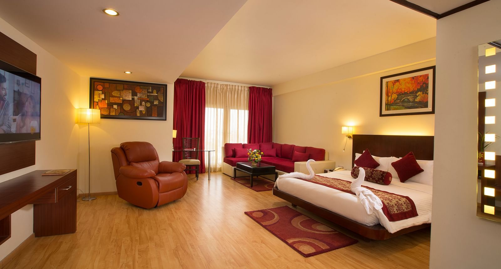a view of Family Suite featuring a bed, a television and a recliner at Hotel Atithi - TGI Grand, Pondicherry