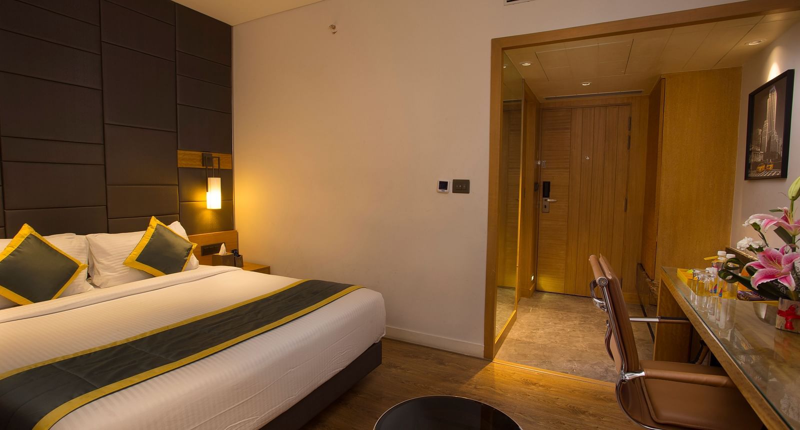 a bedroom with a large bed on the right side opposite to a work desk and chair  - Hotel Fountain Tree By TGI - JP Nagar, Bangalore