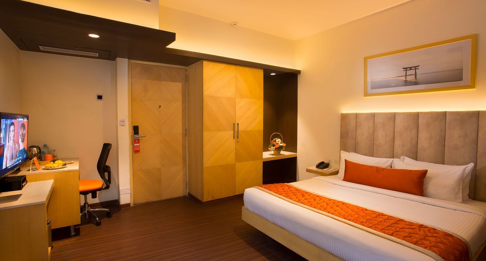 A spacious hotel room with a comfortable bed, ambient lighting and a television, featuring a wooden wardrobe and desk - Hotel Langford Keys by TGI, Shanti Nagar