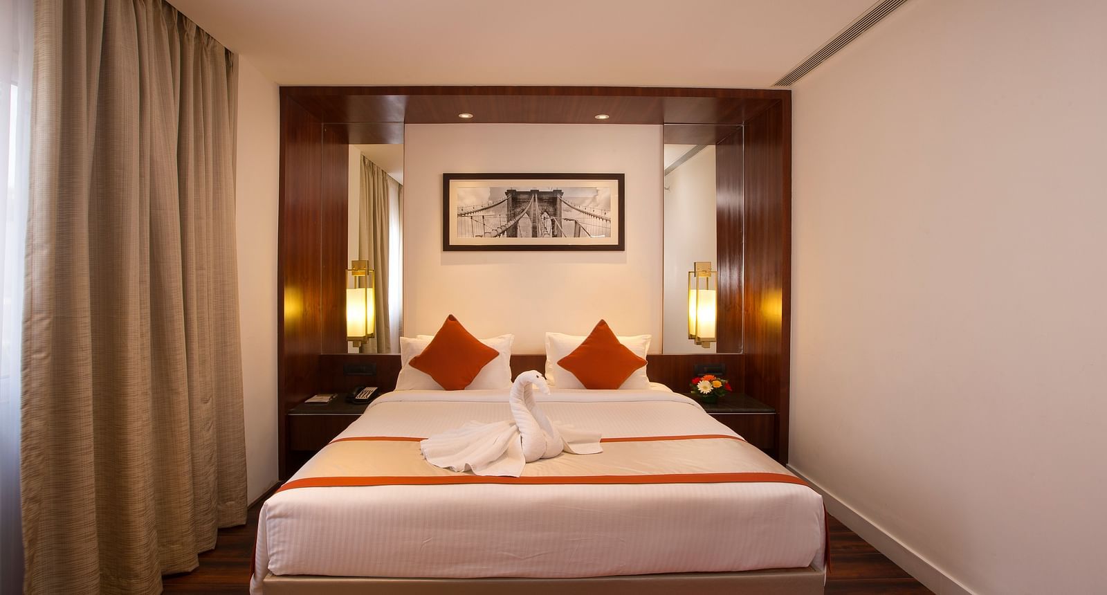 A hotel room featuring a large bed with white linens and red accents, a desk and a wall-mounted TV - Hotel Southend by TGI - Bommasandra, Bangalore
