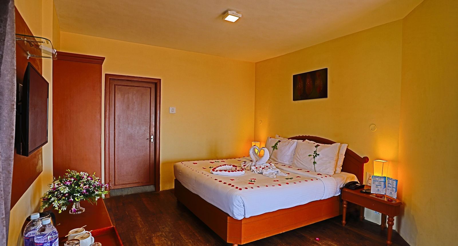 a plush white bed decked with flower petals at La Montana By TGI, Ooty