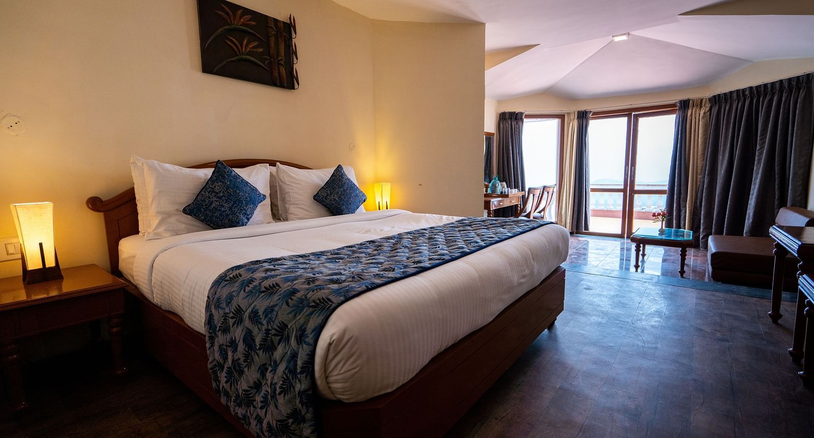 comfy bed with blue duvet and pillows at La Montana By TGI, Ooty