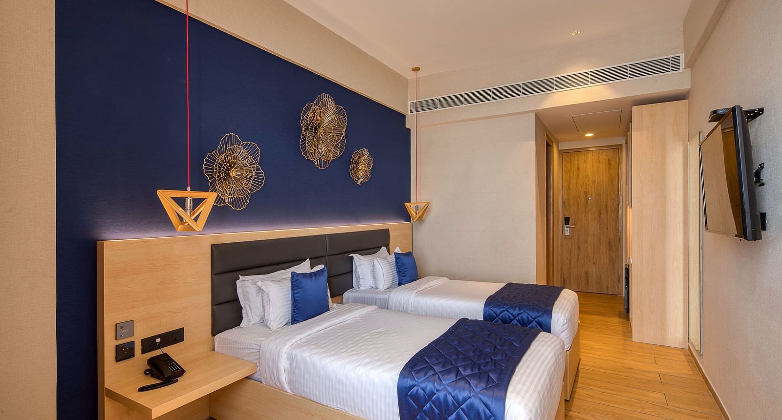 Twin beds with blue bedsheets and pillow covers at Executive Room at Le Foliage by TGI, Bangalore 2