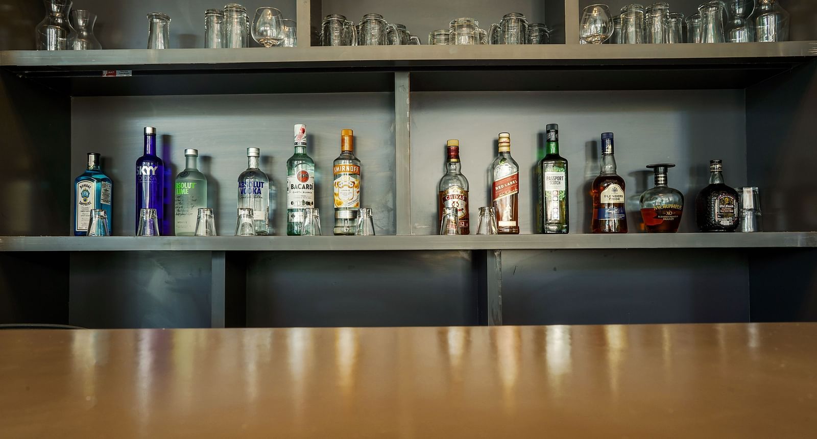 Close-up view of liquor bottles on a bar shelf - TGI Ameya Grand, Goa