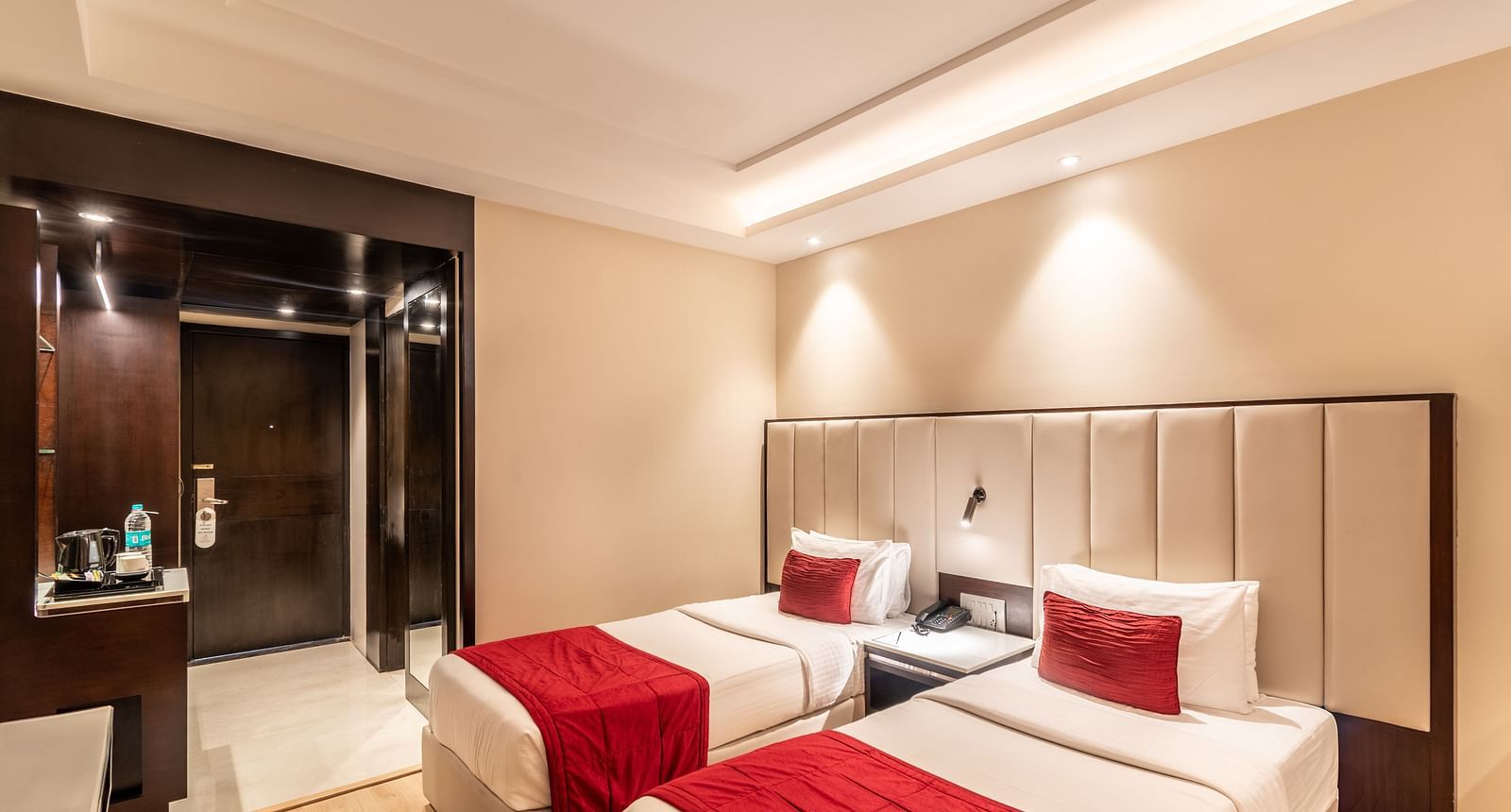 Superior Room with two beds featuring patterned bedding, a desk area, and lighting- TGI Grand Fortuna, Krishnagiri Main Road, Hosur