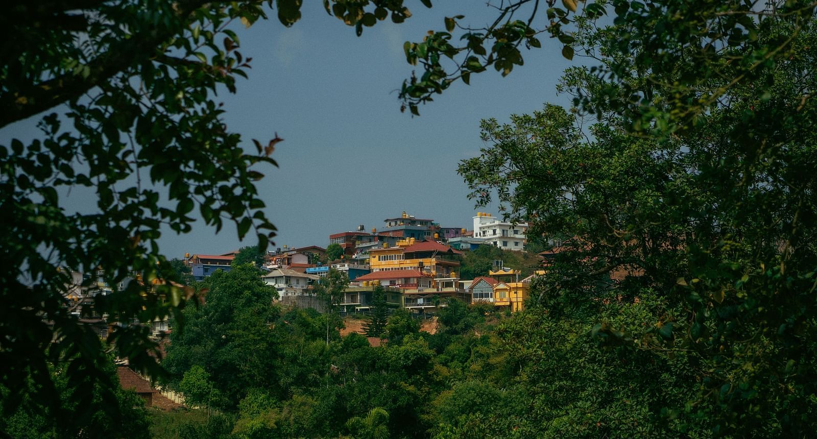 image of the city of coorg with vibrant and colourful buildings surrounded by lush greenery