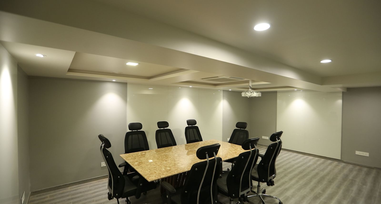 A meeting room setup with a long conference table and chairs - TGI SPS Grand, Coimbatore