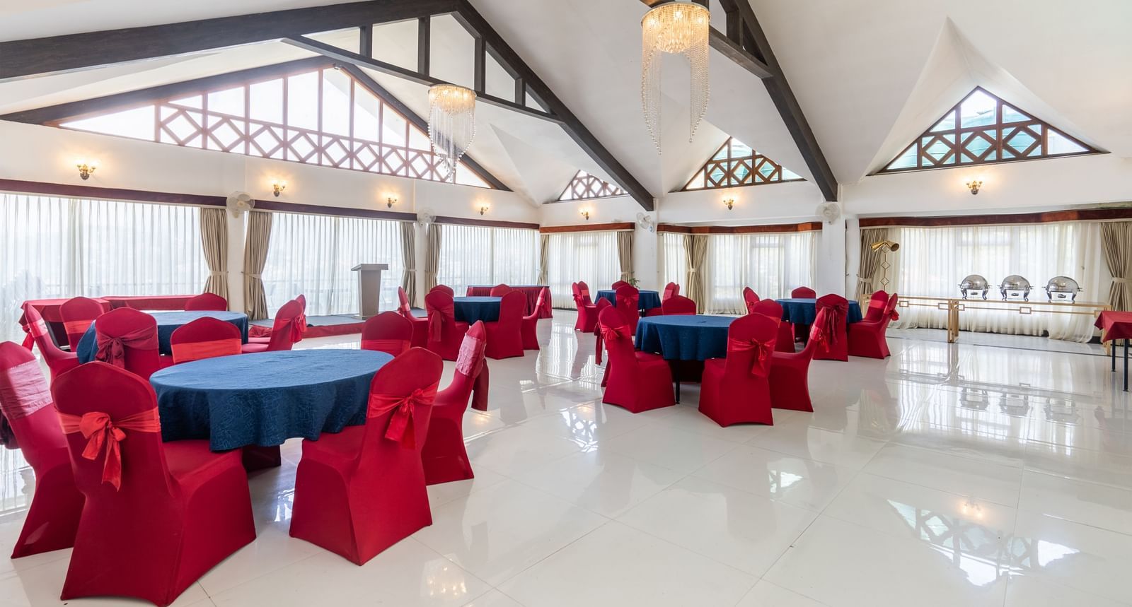 event hall with red chairs and blue table at Summit Lillium Hotel & Spa, Kalimpong