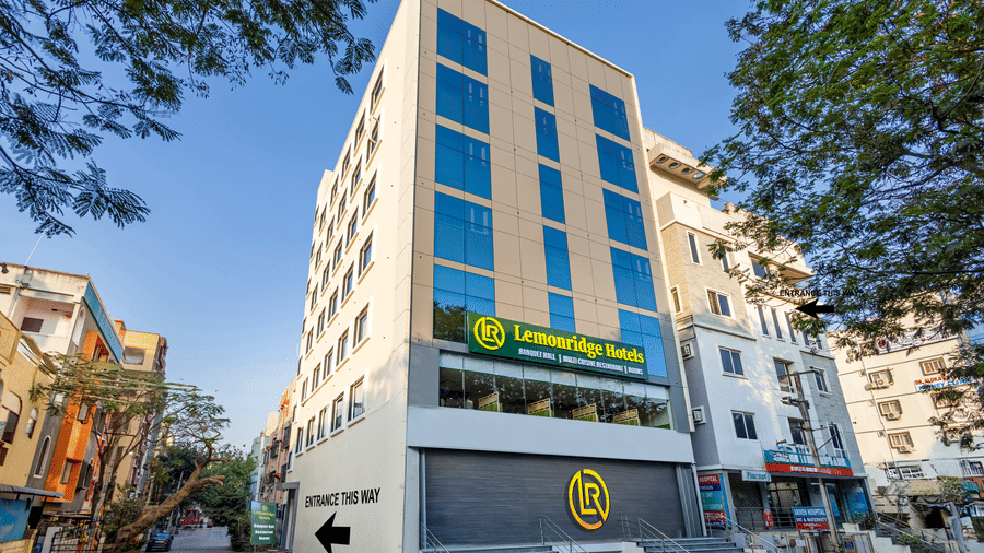 Facade of Lemonridge by Monday Hotels - KPHB featuring a modern multi-story white exterior with blue glass windows, prominent branding signage, and a front staircase entryway.