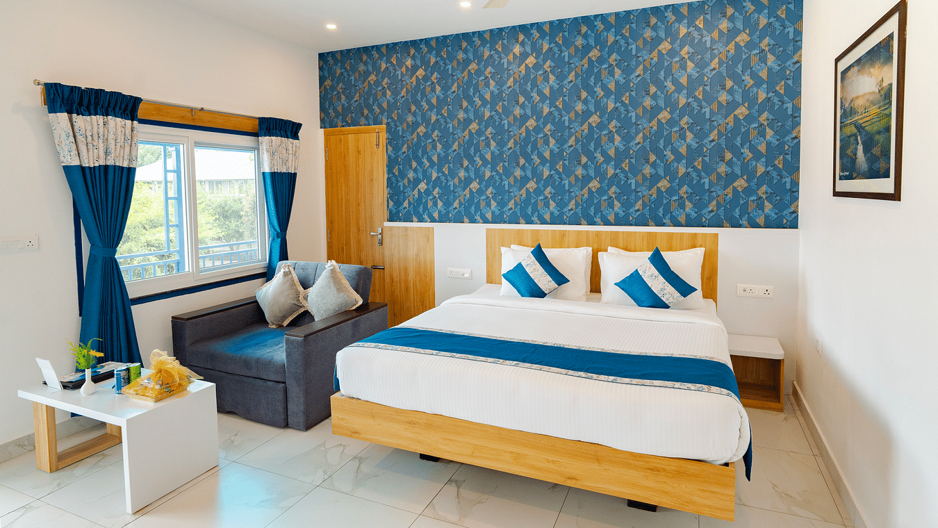  A cosy room with a comfortable double bed, good interiors and a sofa on the side- MGM Whispering Wind's Resorts