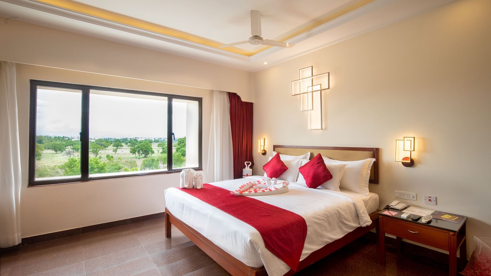 Honeymoon Suite with a plush king sized bed, bedside lamps, and a large window offering natural light and views