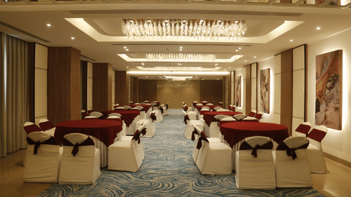A spacious banquet hall with elegant interiors and chairs arranged in a theatre style seating - Tulip Inn, Zirakpur