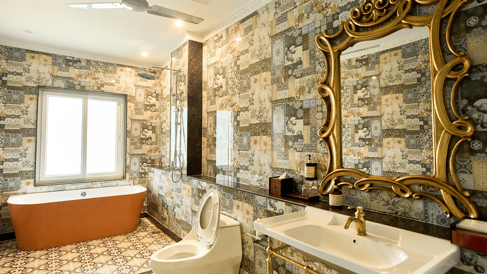 A spacious bathroom with a bathtub, Western toilet, and a washbasin with a wall-mounted mirror above it at Mayfair Manor, Alibag