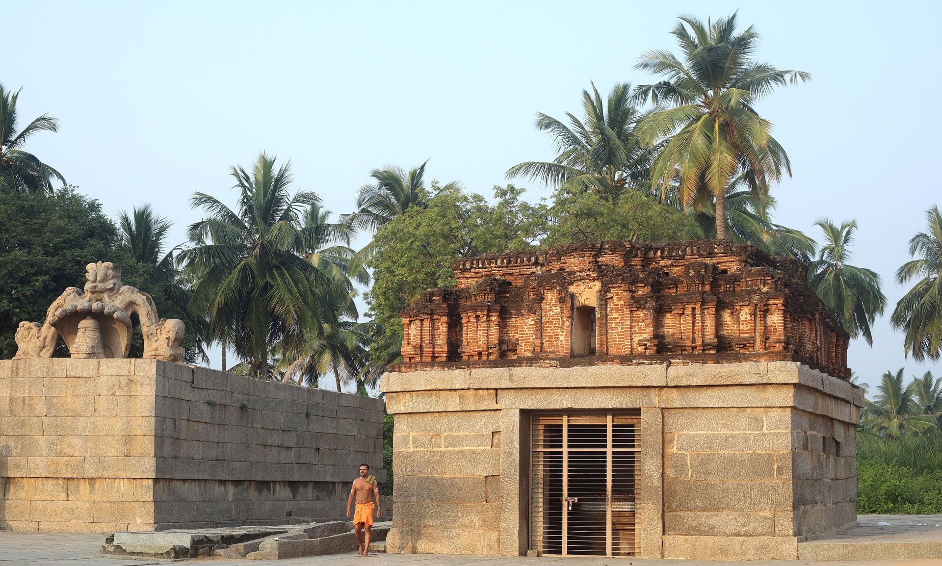 Badavilinga Temple ruins in Hampi with palm trees.