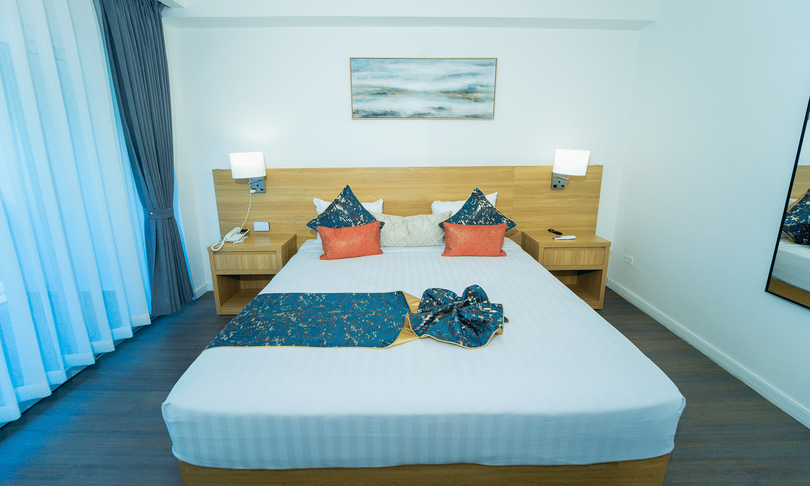 An image of a king size bed with night lamps placed on either side of it in our hotel room in Jamaica - Hotel 39, Jamaica (Montego Bay)