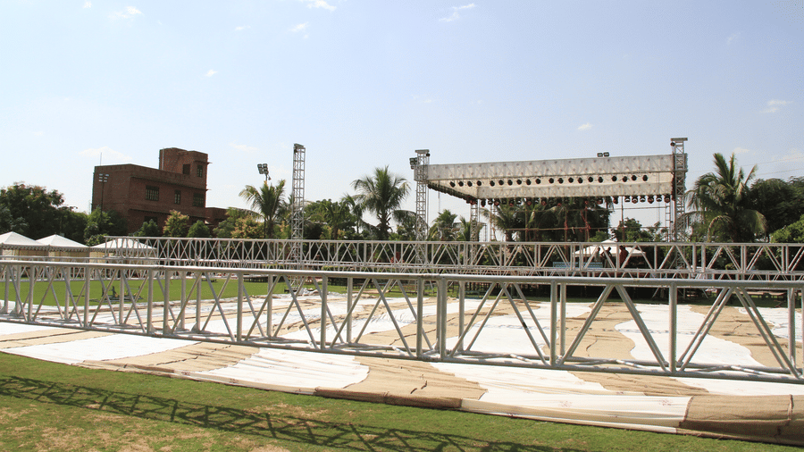 A metal scaffolding stage structure, on a lawn under a blue sky at Garh Govind.