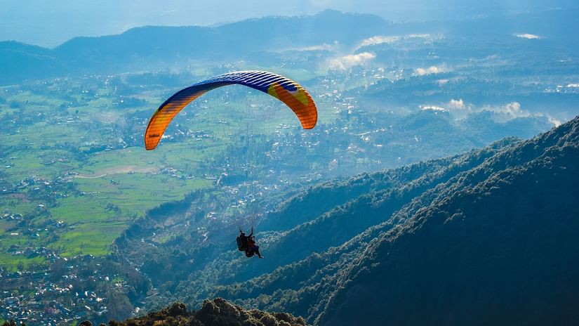 Digantaa Resort - a person paragliding amid mountains