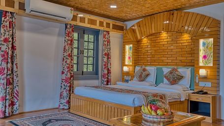 Tastefully designed guest room with wooden textures and natural tones at Royal Comfort Regency, ideal for restful nights.