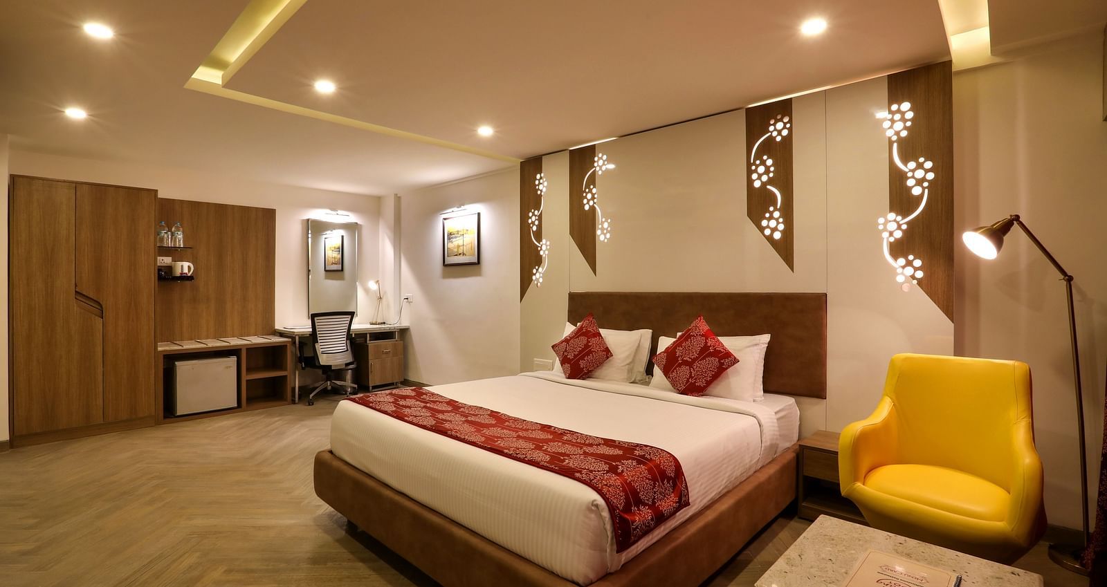 A  bedroom with a king size bed and a sofa and small table on the side, with a workdesk and chair on the other end - Mango Hill Central, Chennai