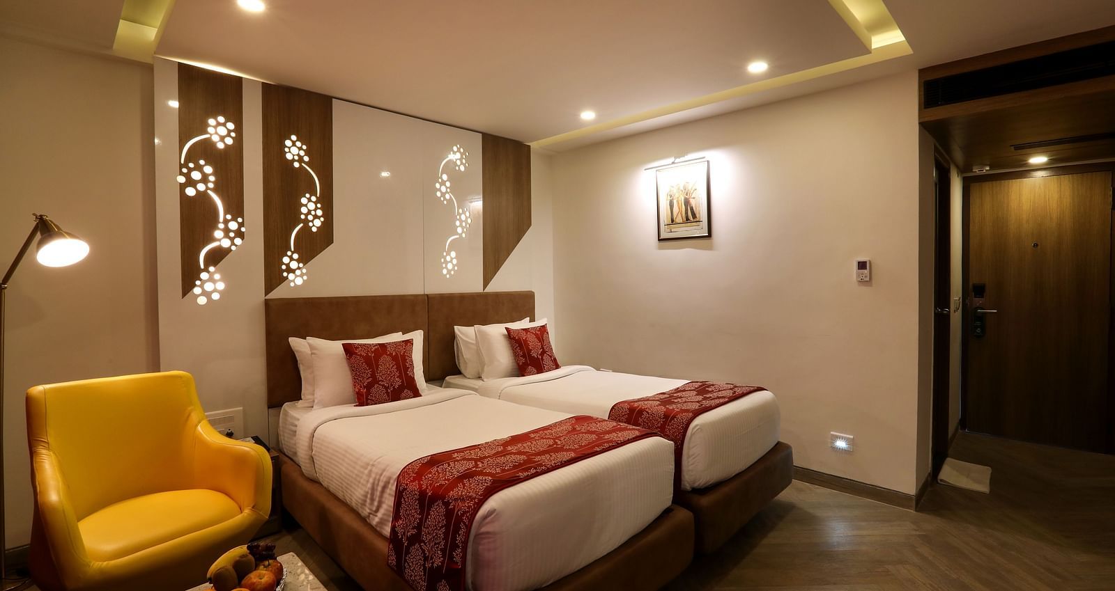 A bedroom with two single beds and a sofa and small table on one end beside the windows - Mango Hill Central, Chennai