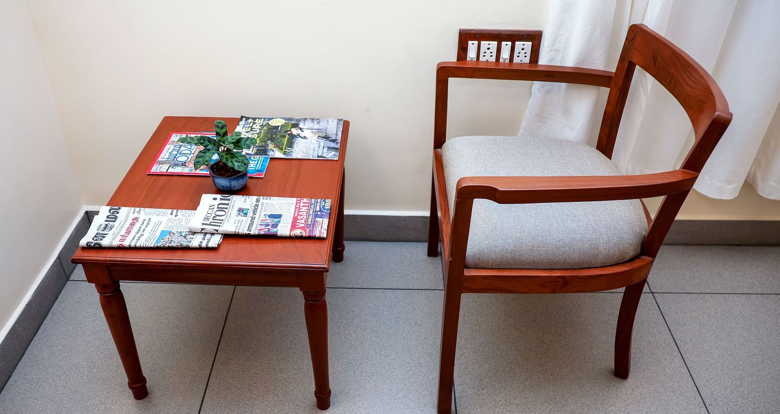 A table and a chair placed at one corne of a room | Mango Hill La Serene, Pondicherry