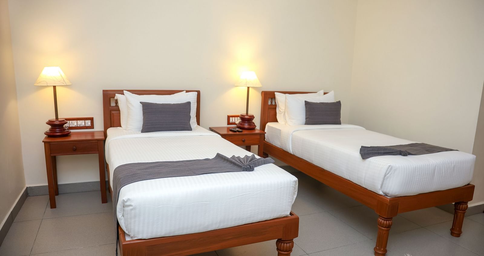 A room that has two similar looking bed with a bedside table beside them  | Mango HIll La Serene, Ponicherry