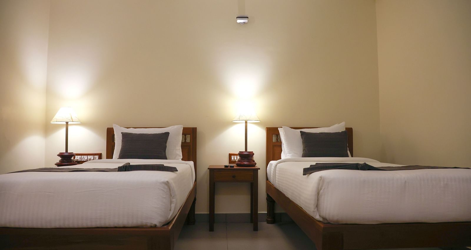 An image of two beds in a room | Mango Hill La Serene, Pondicherry