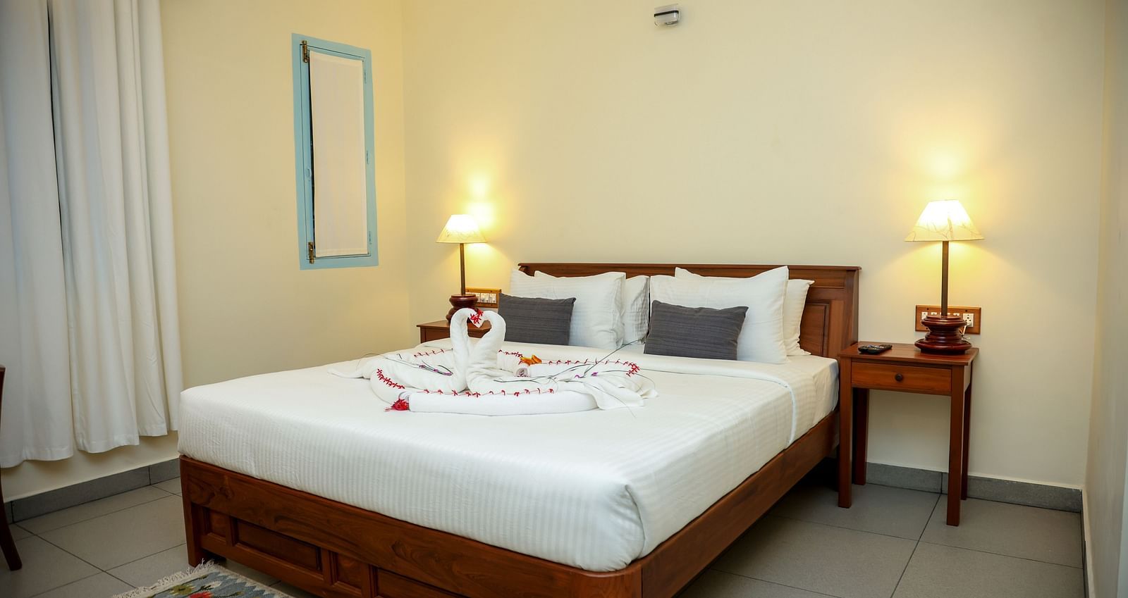 A bedroom which has a bed decorated by towel swans | Mango Hill La Serene, Pondicherry