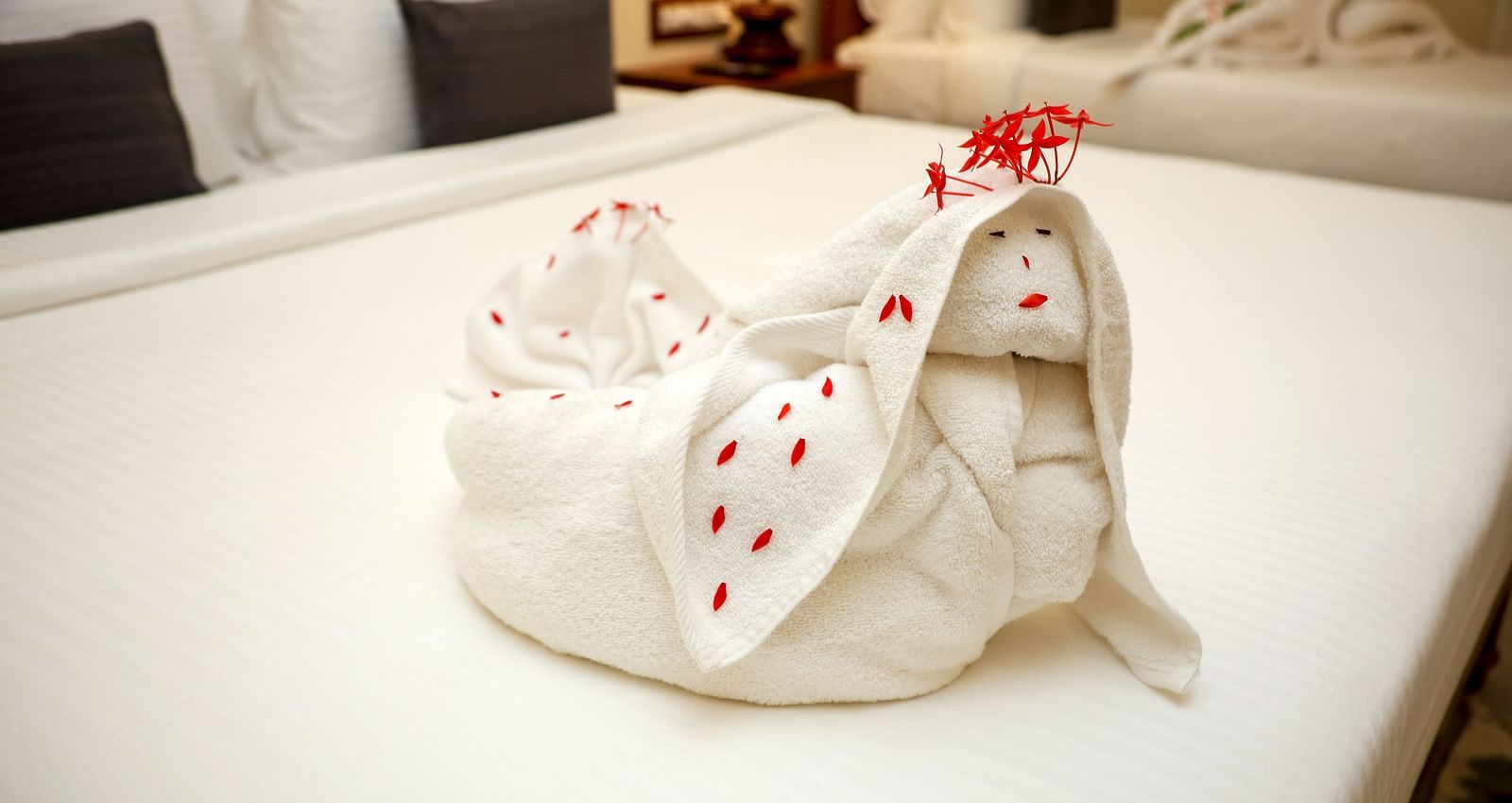 A bed decorate with towels and few flower petals  | Mango Hill La Serene, Pondicherry