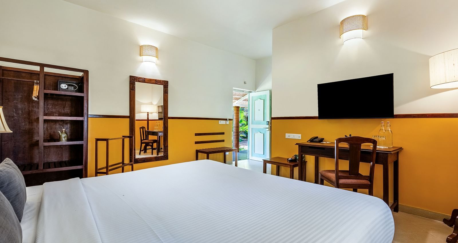 Bright and airy bedroom with a king bed, a workspace, and a view through an open door | Mango Hill Shallow Beach Resort ECR