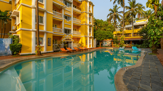 The pool of the hotel surrounded by the hotel building.