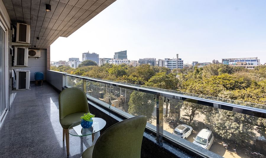 Chairs in the balcony with a city view at Hotel Bawa, Gurgaon.