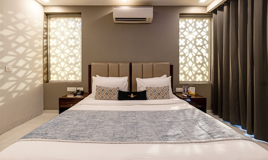 A hotel room with a king size bed, soft lighting, and modern decor at Hotel Bawa, Gurgaon.